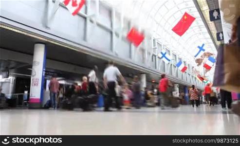 Low angle time lapse of people walking down the terminal of an airport