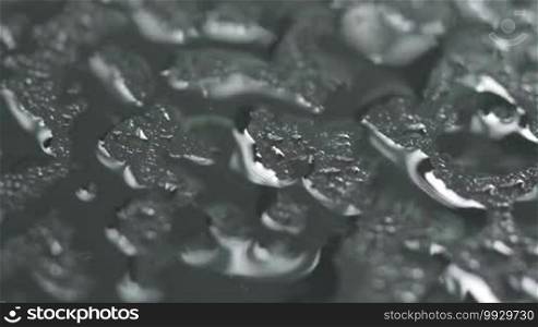 Macro of water sprayed on glass and droplets in motion