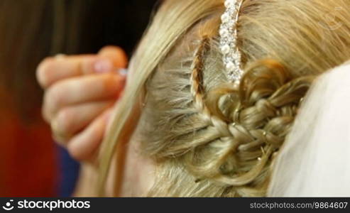 Makeup artist applies makeup to an attractive young bride