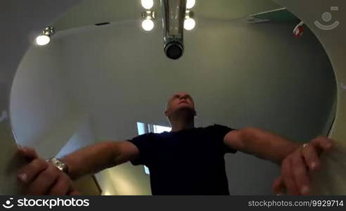 Male beauty, people grooming, body care and morning routine with tired man waking up, looking at mirror and washing face in bathroom at home. Low angle view from sink