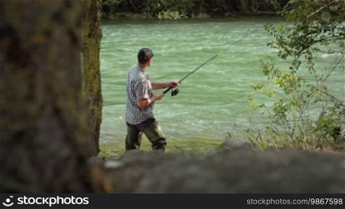 Man and leisure activity, mid adult fisherman on holidays on river, relaxing and fishing. Dolly shot. Part 5 of 8