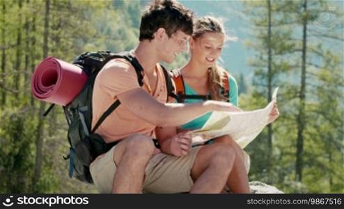 Man and woman during leisure activity on holidays, young people hiking and trekking on mountains, talking and looking at map. Part 2 of 12