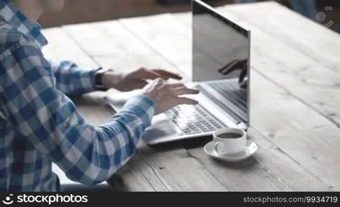 Man in casual clothes using a laptop computer in office