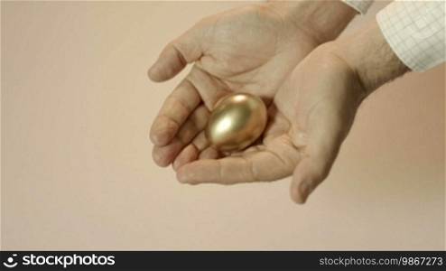 Man showing golden eggs and holding them in hands. Concept of people securing savings, money, precious and valuable things, prizes. Sequence