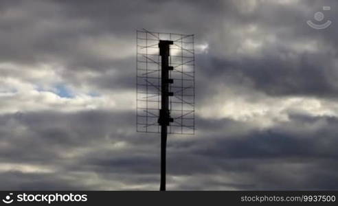 Medium shot of home-based digital TV antenna during a stormy cloudy day time lapse with no birds in it.