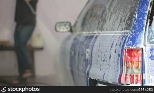 Men wash car with water pressure machine