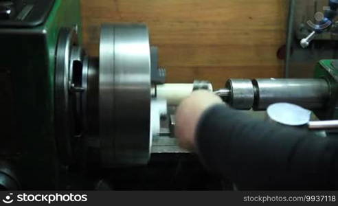 Milling machine operator working in factory workshop. Turner preparing an old lathe machine to work on metal.