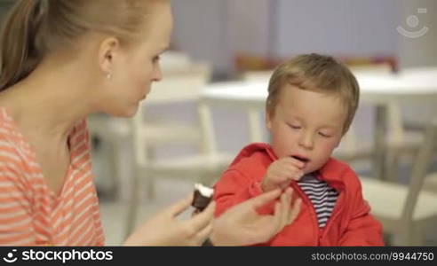 Mom feeds her son in restaurant