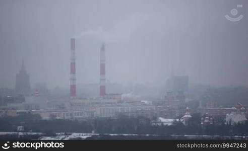 Moscow winter cityscape of Hamovniki district: buildings and a plant with smoking pipes