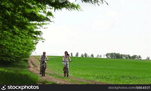 Mother and child riding on a bicycle in a field