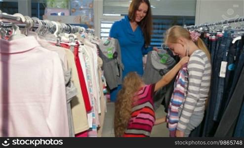 Mother with two daughters shopping for clothes in a clothing store