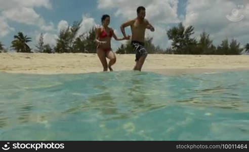 Newlyweds: young adults running and having fun on a tropical beach on the Caribbean Sea in Cuba