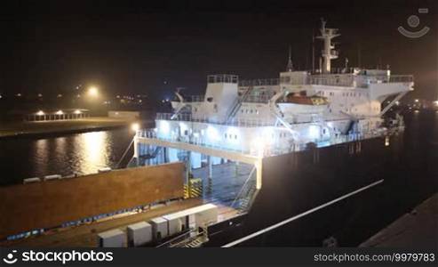 Night lights illuminate the seaport and cargo ship