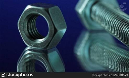 Nuts and bolts on a workbench. Slider shot.