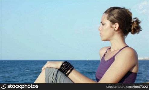 Panning on attractive young Caucasian woman looking at the sea. Copy space
