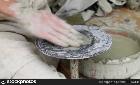 Part I. Potter's hands making a pot in traditional style.