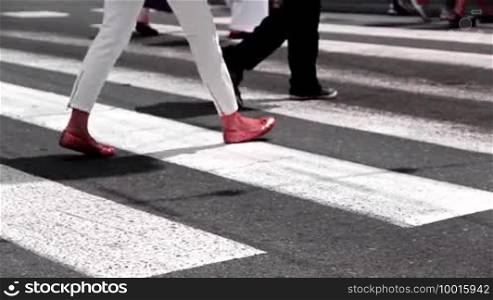 Pedestrians cross a road on a zebra crossing