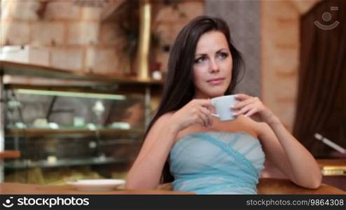 Pensive lady drinking coffee in a coffee shop