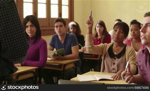 People at school, student raising hand and asking question to professor during class in college, Law School, University of Havana, Cuba