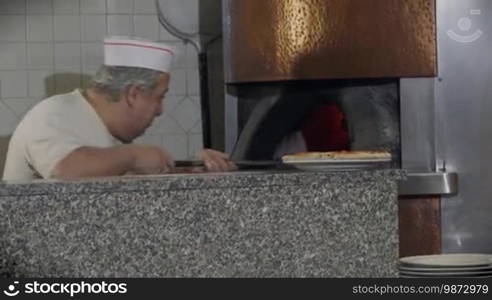 People at work, man working, food preparation, job, profession. Portrait of happy professional cook smiling, skilled chef cooking pizza in wood oven in Italian restaurant kitchen. 10 of 14