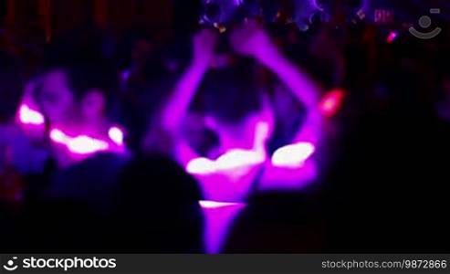 People dancing in a fashion disco club in Barcelona. Dancing party clubbing at night. Music and flash lights. Colorful flash lights in the discotheque.