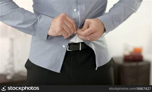 People, man, diet and fashion, frustrated businessman trying to button up a tight shirt after gaining weight