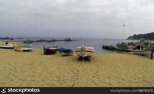 Picturesque Mediterranean fishing boats in La Costa Brava, Girona. Aerial drone shot flying over the barques near the seaside. Typical Mediterranean landscape wooden boats and pristine beaches.