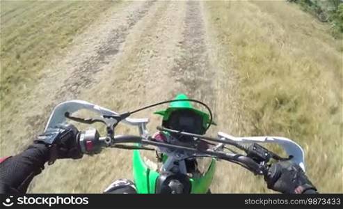 Point of View: Enduro biker riding motorcycle on dirt track, action camera mounted on the chest