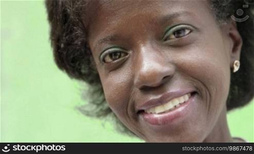 Portrait of a happy mature African American woman looking at the camera and smiling. Sequence