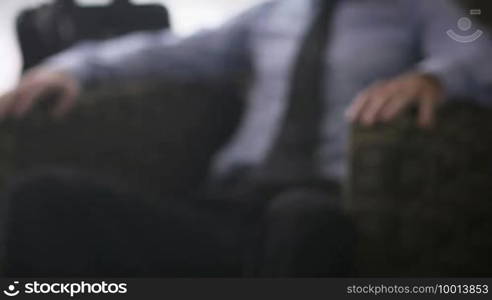 Portrait of happy Caucasian businessman smiling at camera in hotel room during business trip. Rack focus