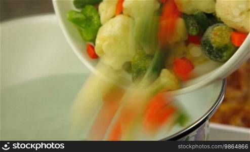 Pouring the vegetables in a pot with boiling water