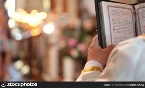Priest reading the Bible in church