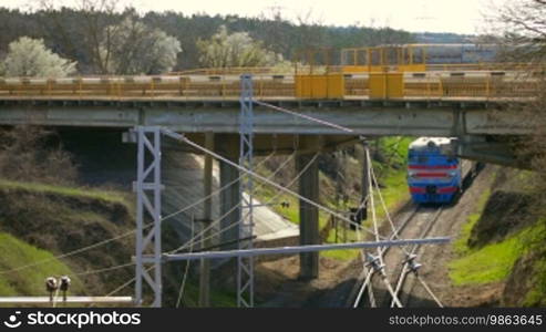 Railway train runs under the road bridge