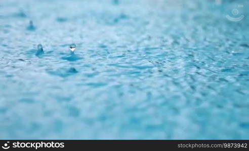 Rain drops closeup on water surface