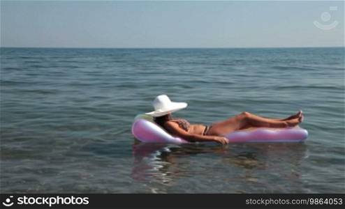 Relaxed girl wearing a white hat on a float