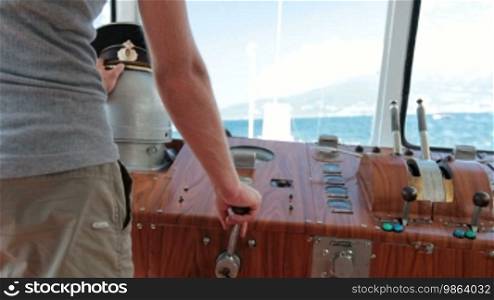 Sailor controls boat in the wheelhouse