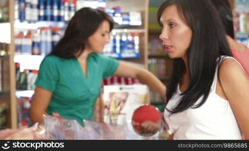 Sales Person Assisting Female Shopper in Choice of Beauty Care Products