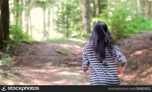 Scared teenage girl running in the forest. Someone is following her.