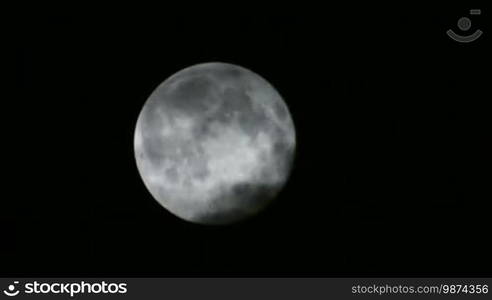 Scary Full Moon in a Cloudy Night. Very detailed lunar surface with its valleys and craters. Suitable for fear, scary and terror scenes. Awesome full moon. Night of wolf, Halloween night, nightmare.