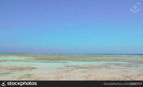 Scenic view of sea with clear shallow water and cloudless blue sky. Vacation at the seaside