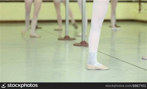 School of ballet with female ballerina exercising and dancing during lesson