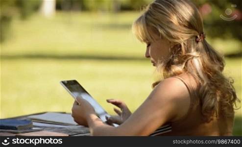 School, technology, and education: Young woman with iPad studying for university test