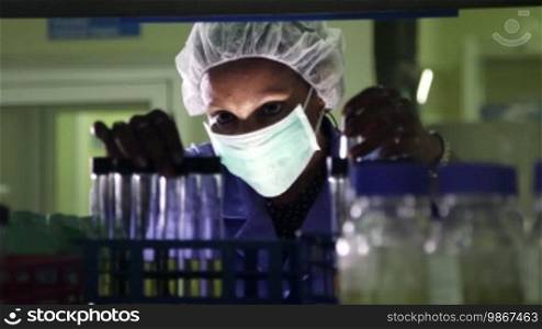 Science and research: woman working as a chemist looking at a test tube in a laboratory