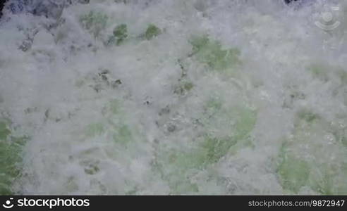 Sea foam in green waves