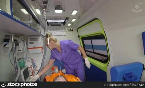 Senior person receiving medication via intravenous therapy in ambulance during transportation to hospital