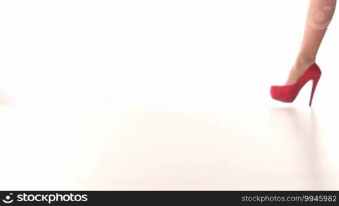 Sexy woman red shoes walking in the studio