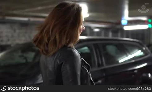 Sexy woman wearing leather jacket and shirt in the car park garage