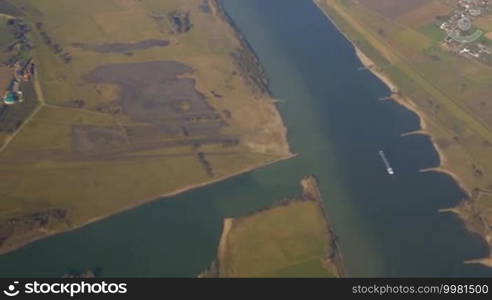 Shot of people settlements and green fields made from the board on the plane.