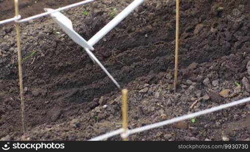 Side shot plowing the ground with hand rake, agriculture