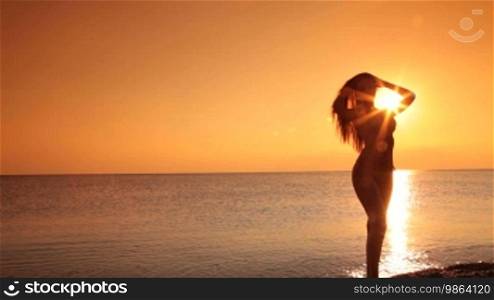 Silhouette of a woman at sunset by the sea